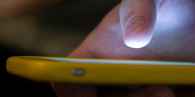 In this Sunday, Aug. 11, 2019, photo, a man uses a cell phone in New Orleans. Quick help for suicidal thoughts and other mental health emergencies may soon be as easy as 9-8-8. The United States’ first nationwide three-digit mental health crisis hotline goes live on Saturday, July 16, 2022. 