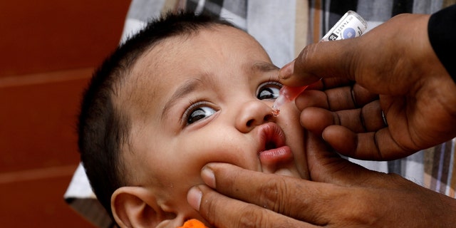 A small child receives drops of polio vaccine during a polio campaign in a poor area of ​​Karachi, Pakistan, on July 20, 2020. 