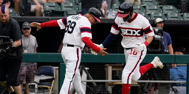 Chicago White Sox's AJ Pollock, right, celebrates with third base coach Joe McEwing after hitting a three-run home run during the second inning of a baseball game against the Cleveland Guardians in Chicago, Sunday, July 24, 2022. 