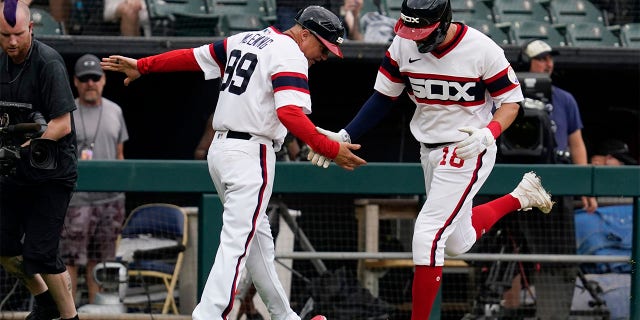 Chicago White Sox's AJ Pollock, right, celebrates with third base coach Joe McEwing after hitting a three-run home run during the second inning of a baseball game against the Cleveland Guardians in Chicago, Sunday, July 24, 2022.