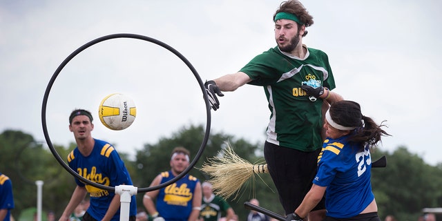 A member of the Loyola University quidditch team, 緑で, scores on UCLA's Tiffany Chow during their match at the Quidditch World Cup VI in Kissimmee, フラ。, 四月に 14, 2013.