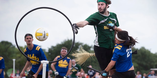 A member of the Loyola University quidditch team, in green, scores on UCLA's Tiffany Chow during their match at the Quidditch World Cup VI in Kissimmee, Fla., April 14, 2013.