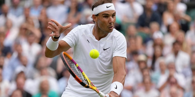 Rafael Nadal returns to Taylor Fritz in a men's singles quarterfinal match at Wimbledon in London, Wednesday, July 6, 2022.