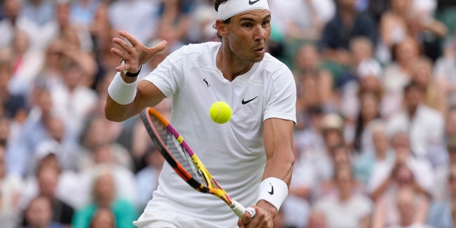 Rafael Nadal returns to Taylor Fritz in a men's singles quarterfinal match at Wimbledon in London, Wednesday, July 6, 2022.