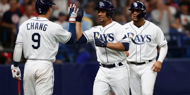 Tampa Bay Rays' Francisco Mejia, center, celebrates with the Ray's Yu Chang after scoring against the Boston Red Sox during the sixth inning of a baseball game Tuesday July 12, 2022, in St. Petersburg, Fla.