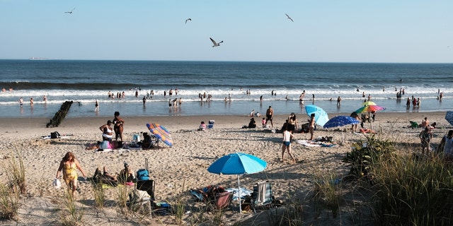 People enjoy a warm evening at Rockaway Beach on July 19, 2022 in New York City. 