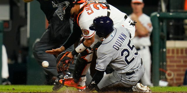Tampa Bay Rays' Roman Quinn (25) scores a run as Baltimore Orioles catcher Robinson Chirinos waits for the throw on a two-run bases loaded double by Randy Arozarena during the 10th inning of a baseball game, Wednesday, July 27, 2022, in Baltimore.  The Rays won 6-4 in ten innings.  Rays' Taylor Walls also scored on the play. 