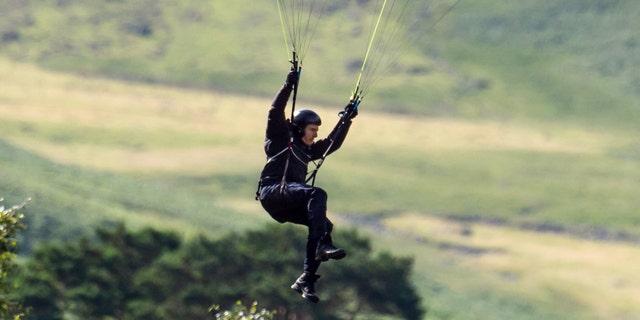 Tom Cruise parachutes after jumping off a mountain during filming of "Mission: Impossible 8."