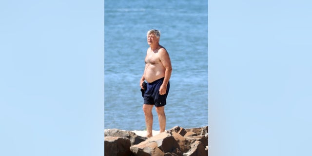The 64-year-old actor wore navy blue swim trunks as he strolled by the sea.