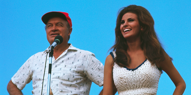 Comedian Bob Hope and actress Raquel Welch entertain American troops at an unidentified outdoor site in Vietnam, circa 1967. 