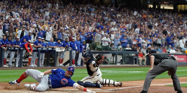 Chicago Cubs' Seiya Suzuki slides safely home after hitting an inside-the-park home run during the ninth inning of a baseball game against the Milwaukee Brewers Monday, July 4, 2022, in Milwaukee.