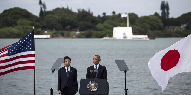 U.S. President Barack Obama delivers remarks while Japanese Prime Minister Shinzo Abe listens at Joint Base Pearl Harbor Hickam's Kilo Pier on December 27, 2016 in Honolulu, Hawaii. Abe is the first Japanese prime minister to visit Pearl Harbor with a U.S. president and the first to visit the USS Arizona Memorial.