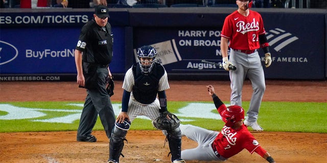 Cincinnati Reds' Brandon Drury (22) watches as Donovan Solano (7) slides past New York Yankees catcher Jose Trevino to score on a single by Jonathan India during the ninth inning of a baseball game Tuesday, July 12, 2022, in New York. The Reds won 4-3.