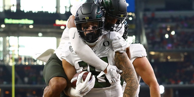 Oregon Ducks tight end Spencer Webb (18) celebrates a first-quarter touchdown with wide receiver Johnny Johnson III (3) on his back against the Auburn Tigers at AT and T Stadium on August 31, 2019 in Arlington, Texas.