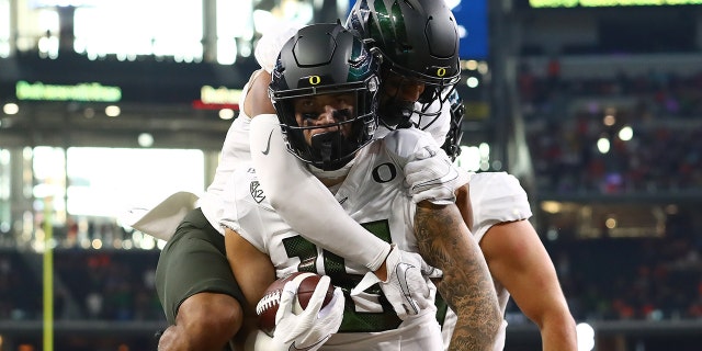 Oregon Ducks tight end Spencer Webb (18) celebrates his first quarter touchdown with receiver Johnny Johnson III (3) on his back against the Auburn Tigers at AT and T Stadium Aug 31, 2019, in Arlington, Texas.
