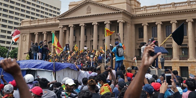 Protesters, many carrying Sri Lankan flags, gathered outside the president's office in Colombo, Sri Lanka on Saturday, July 9, 2022. 