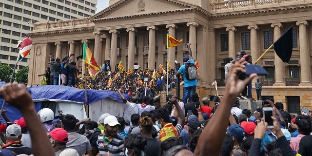 Manifestantes, muitos carregando bandeiras do Sri Lanka, se reuniram do lado de fora do escritório do presidente em Colombo, Sri Lanka, no sábado.  (Foto AP/Thilina Kaluthotage)