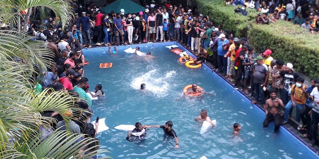 Protesters demanding the resignation of Sri Lanka's President Gotabaya Rajapaksa swim in a pool inside the compound of Sri Lanka's Presidential Palace in Colombo on July 9, 2022. 