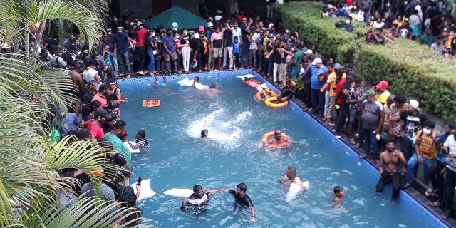 Protesters demanding the resignation of Sri Lanka's President Gotabaya Rajapaksa swim in a pool inside the compound of Sri Lanka's Presidential Palace in Colombo on July 9, 2022.  (Photo by AFP via Getty Images)