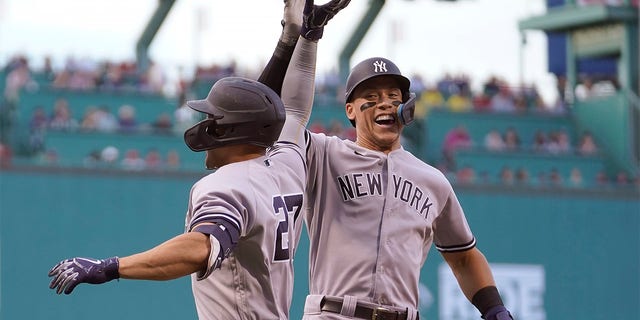New York Yankees' Giancarlo Stanton, left, celebrates with Aaron Judge, right, after hitting a two run home run allowing Judge to score in the first inning of a baseball game against the Boston Red Sox, Sunday, July 10, 2022, in Boston. 