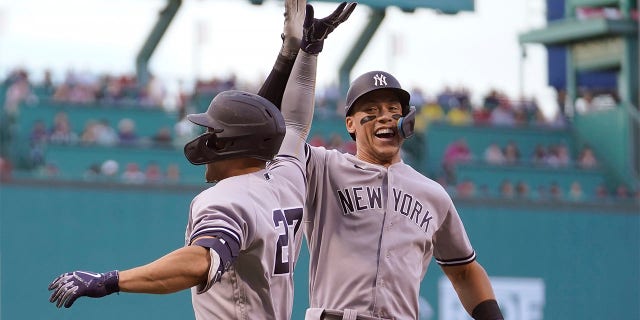 New York Yankees' Giancarlo Stanton, left, celebrates with Aaron Judge, right, after hitting a two run home run allowing Judge to score in the first inning of a baseball game against the Boston Red Sox, Sunday, July 10, 2022, in Boston.