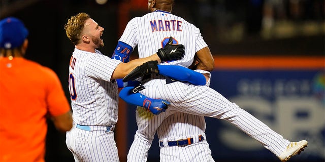 New York Mets' Pete Alonso (20) celebrates with Starling Marte after Marte hit an RBI single during the ninth inning of the team's baseball game against the New York Yankees on Wednesday, July 27, 2022, in New York. The Mets won 3-2. 