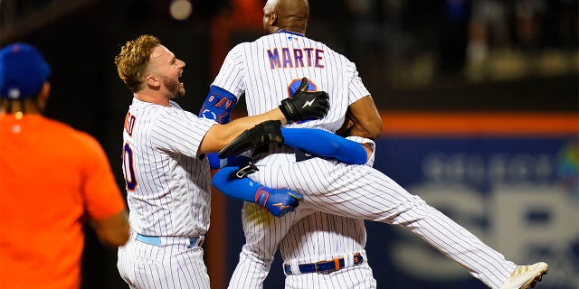 New York Mets' Pete Alonso (20) celebrates with Starling Marte after Marte hit an RBI single during the ninth inning of the team's baseball game against the New York Yankees on Wednesday, July 27, 2022, in New York. The Mets won 3-2.