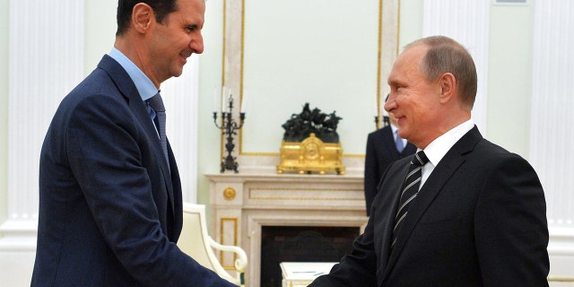 Russian President Vladimir Putin shakes hands with his Syrian counterpart Bashar al-Assad during a meeting at the Kremlin in Moscow Oct. 20, 2015.