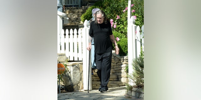 The 73-year-old rock star wore a black T-shirt and matching black pants as he left his son's house after undergoing surgery last month.