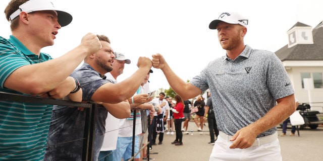 Talor Gooch fist bumps a fan during the LIV Golf Invitational - Portland at Pumpkin Ridge Golf Club on July 2, 2022, in North Plains, Oregon.