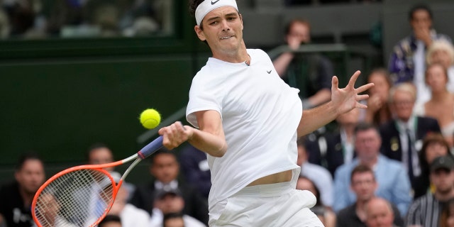 Taylor Fritz returns to Rafael Nadal in a men's singles quarterfinal match at Wimbledon in London, Wednesday, July 6, 2022.