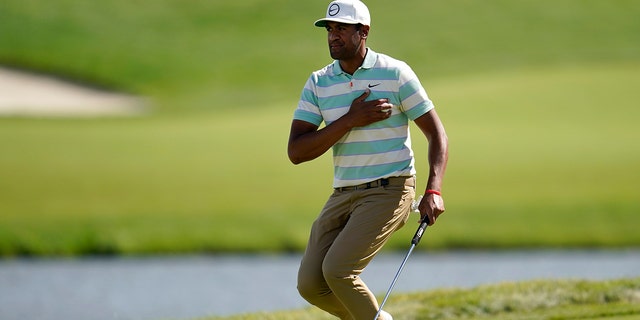 Tony Finau places the ball to his chest and reacts to his putt for par on the 17th green during the final round of the 3M Open golf tournament at the Tournament Players Club in Blaine, Minn., Sunday, July 24, 2022. 
