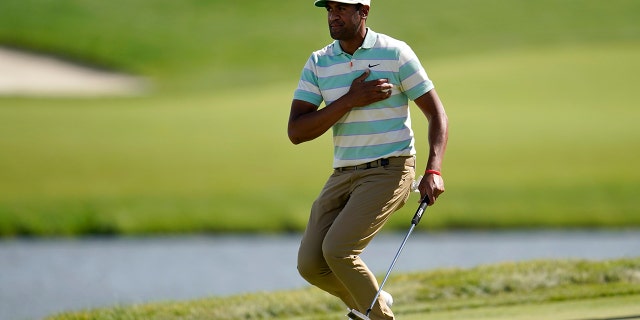 Tony Finau places the ball to his chest and reacts to his putt for par on the 17th green during the final round of the 3M Open golf tournament at the Tournament Players Club in Blaine, Minn., Sunday, July 24, 2022.