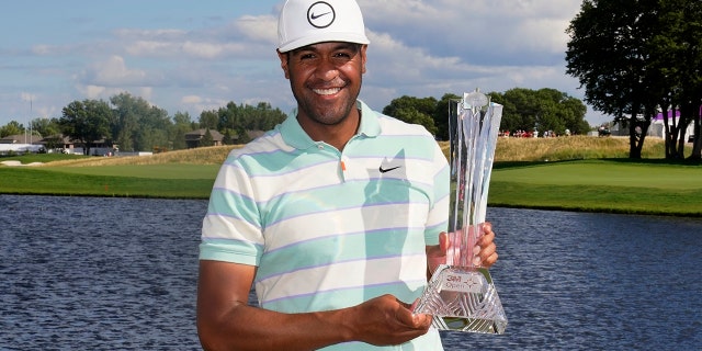 Tony Finau poses for photos with the trophy after his win in the 3M Open golf tournament at the Tournament Players Club in Blaine, Minn., Sunday, July 24, 2022.