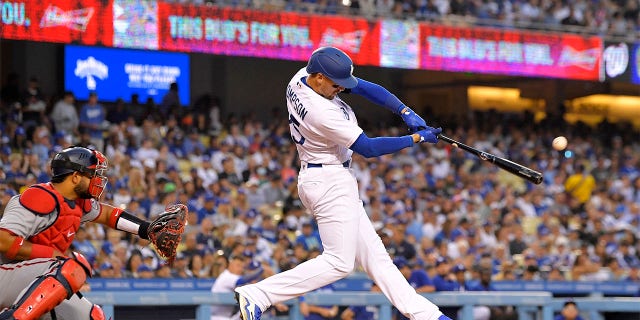 Los Angeles Dodgers' Trayce Thompson, right, hits a solo home run as Washington Nationals catcher Keibert Ruiz watches during the third inning of a baseball game Monday, July 25, 2022, in Los Angeles.