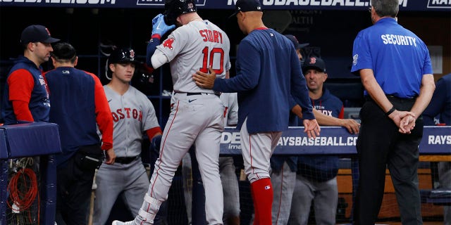 Boston Red Sox manager Alex Cora, right, walks the Red Sox's Trevor Story off the field against the Tampa Bay Rays during the fifth inning of a baseball game Tuesday July 12, 2022, in St. Petersburg, Fla.