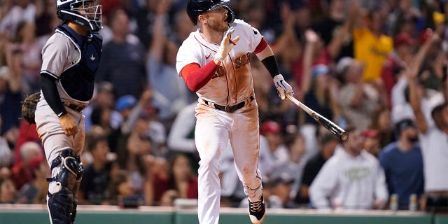 Boston Red Sox's Trevor Story, right, hits a three-run double as New York Yankees' Jose Trevino, left, looks on in the seventh inning of a baseball game, Sunday, July 10, 2022, in Boston. The Red Sox won 11-6.