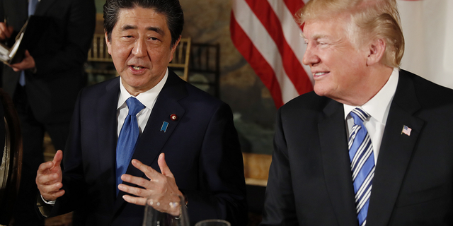 US President Donald Trump is watching Japanese Prime Minister Shinzo Abe speak while dining at Mar-a-Lago's residence in Trump on April 18, 2018 in Palm Beach, Florida.