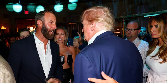 Former US President Trump (2nd R), talks with team captain Dustin Johnson (L) of 4 Aces GC as Paulina Gretzky (2nd L) and former first lady Melania Trump (R) look on during the welcome party for the LIV Golf Invitational - Bedminster at Gotham Hall on July 27, 2022 in New York, New York.