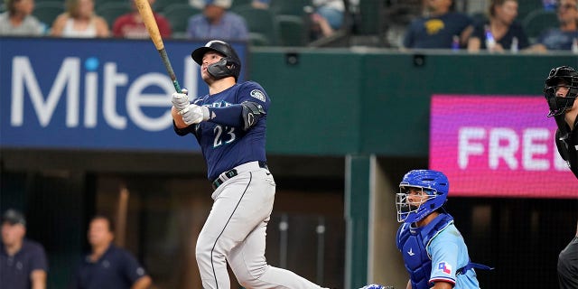 Seattle Mariners' Ty France (23) and Texas Rangers catcher Meibrys Viloria watch France's solo home run sail away during the fifth inning of a baseball game in Arlington, Texas, Sunday, July 17, 2022.