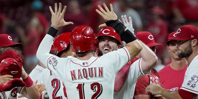 Tyler Naquin #12 and Mike Moustakas #9 of the Cincinnati Reds celebrate when Mustakas made a walk-off sacrificial fly in the ninth inning to beat the New York Mets 1-0 at Great American Ball Park on July 05, 2022 in Cincinnati, Ohio .  , 