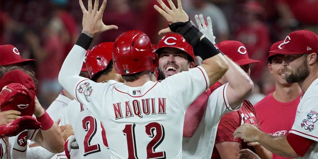 Tyler Naquin #12 and Mike Moustakas #9 of the Cincinnati Reds celebrate after Moustakas hit a walk-off sacrifice fly in the ninth inning to beat the New York Mets 1-0 at Great American Ball Park on July 05, 2022 in Cincinnati, Ohio.