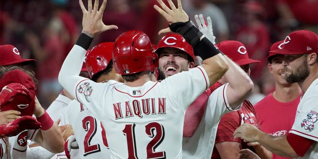 Tyler Naquin #12 and Mike Moustakas #9 of the Cincinnati Reds celebrate when Mustakas made a walk-off sacrificial fly in the ninth inning to beat the New York Mets 1-0 at Great American Ball Park on July 05, 2022 in Cincinnati, Ohio .  , 