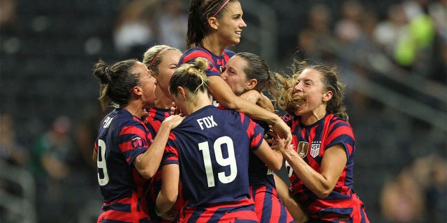 United States' Alex Morgan, top, is congratulated after scoring her side's opening goal from the penalty spot against Canada during the CONCACAF Women's Championship final soccer match in Monterrey, Mexico, Monday, July 18, 2022.