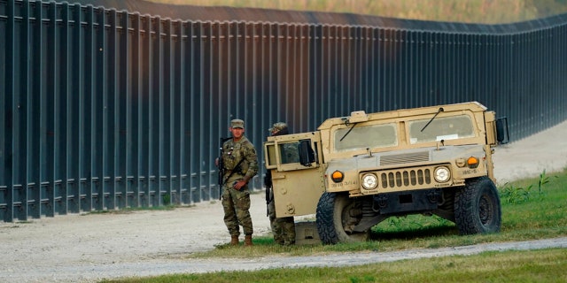 National Guardsmen stood watch near the International Bridge, where thousands of Haitian migrants created a makeshift camp, on Sept.  18, 2021, in Del Rio, Texas.