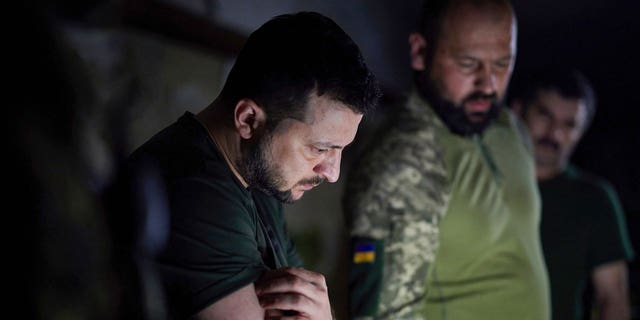 In this photo provided by the Ukrainian Presidential Press Office, Ukraine's president, Volodymyr Zelenskyy, left, listens to a report about the front line in the Donetsk region, Ukraine, on Sunday, June 5, 2022. 