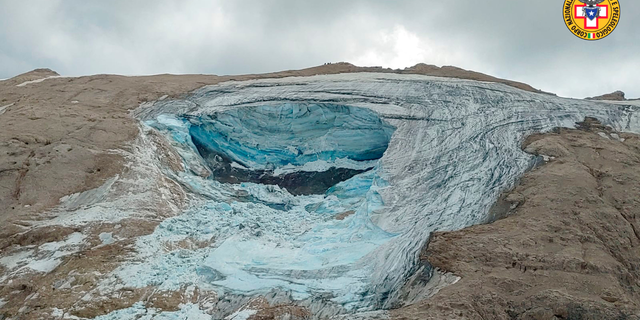 This image released on Sunday, July 3, 2022, by the Italian National Alpine and Cave Rescue Corps shows the glacier in Italy's Alps near Trento a large chunk of which has broken loose, killing at least six hikers and injuring eight others. Alpine rescue service officials, which provided that toll Sunday evening, said it could take hours to determine if any hikers might be missing. The National Alpine and Cave Rescue Corps tweeted that the search of the involved area of Marmolada peak involved at least five helicopters and rescue dogs.