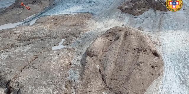 This image released on Sunday, July 3, 2022, by the Italian National Alpine and Cave Rescue Corps shows the glacier in Italy's Alps near Trento a large chunk of which has broken loose, killing at least six hikers and injuring eight others. Alpine rescue service officials, which provided that toll Sunday evening, said it could take hours to determine if any hikers might be missing. The National Alpine and Cave Rescue Corps tweeted that the search of the involved area of Marmolada peak involved at least five helicopters and rescue dogs. 