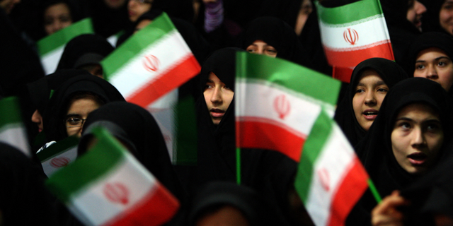 Schoolgirls wave Iranian flags during a ceremony marking the 33th anniversary of Ayatollah Ruhollah Khomeini's return from exile at Khomeini's mausoleum in Tehran on Feb. 1, 2012.