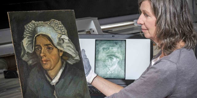 Senior restorer Leslie Stevenson examines the head of a peasant woman next to an x-ray of a hidden Van Gogh self-portrait. A previously unknown self-portrait of Vincent van Gogh has been discovered behind another painting by the artist. The National Gallery of Scotland said on Thursday that it was discovered on Van Gogh's back. "Head of a peasant woman" when experts took an x-ray of the canvas before the upcoming exhibition. (Neil Hanna via AP)